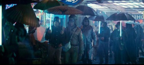 La population sous la pluie abritée par des parapluies dans Blade Runner